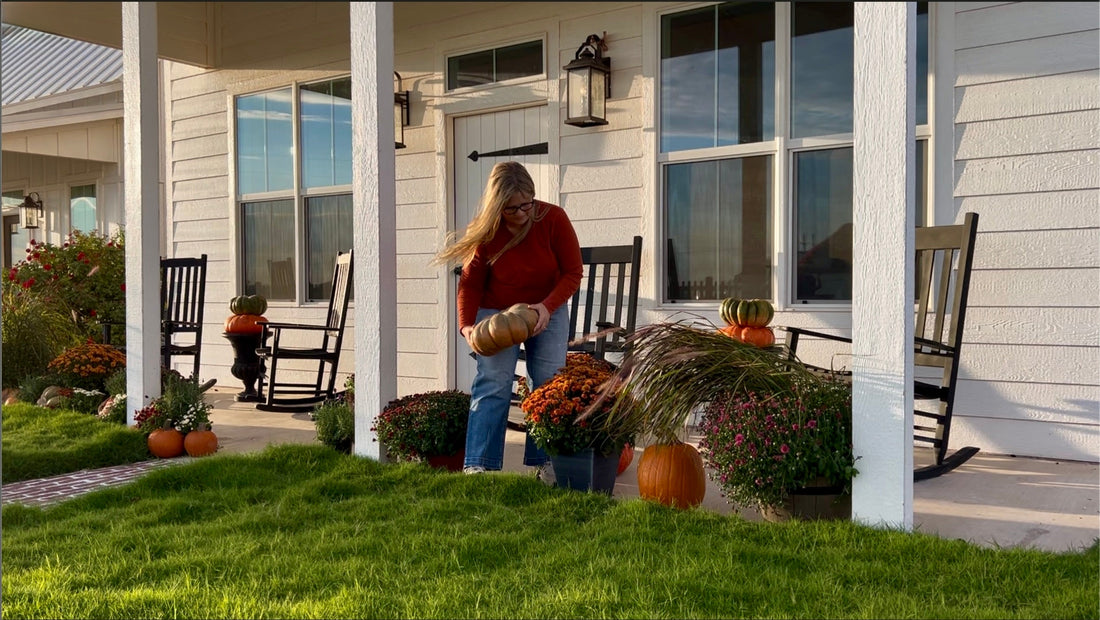 Decorating the porch for fall with pumpkins and chrysanthemums.